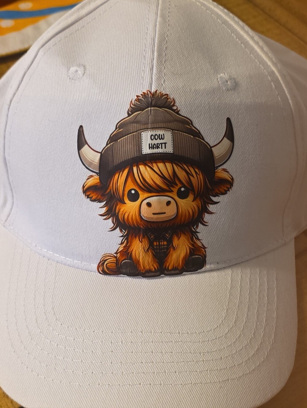 White Baseball Cap with Orange Highland Cow Graphic